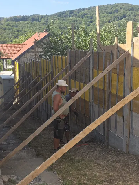 Oplata za betonski zid, poduprta drvenim gredama